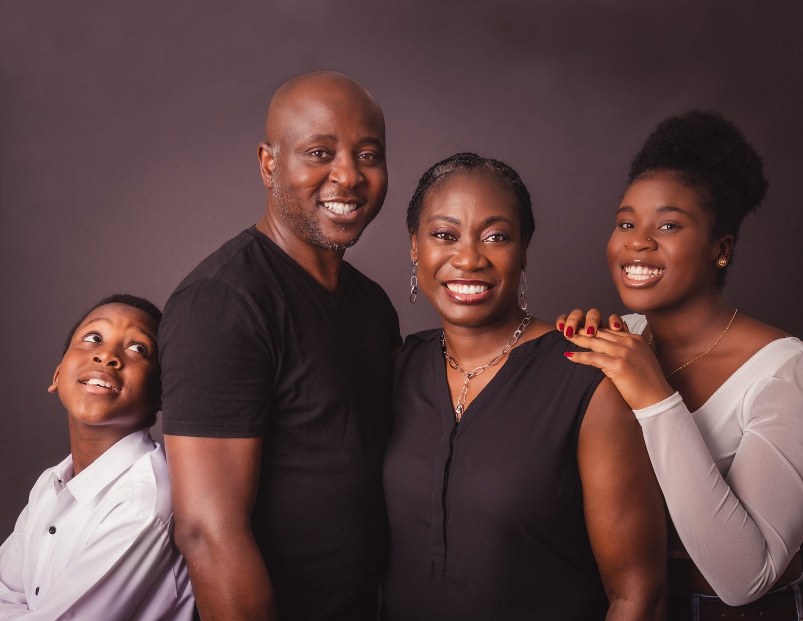 unboxed-portraits_Beautiful black family of four - father, wife, son and daughter, smiling looking into the lens.